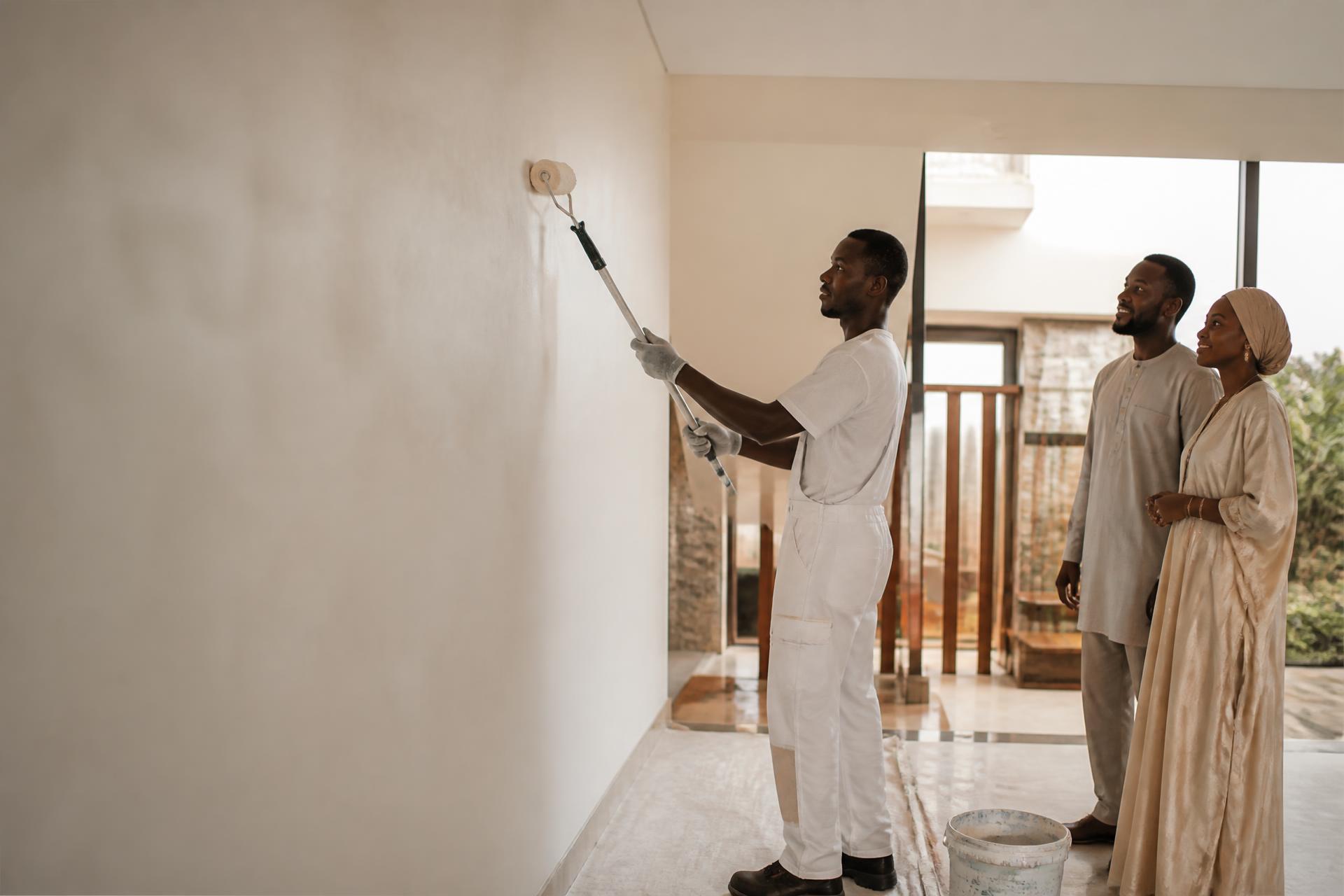 Peintre africain réalisant une finition intérieure auprès des propriétaires